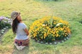 Girl kneeing in front of flowers