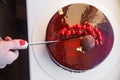 Girl knife ombre marble mousse cake decorated with red mirror glaze and berries. Royalty Free Stock Photo