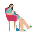 A girl knits clothes in a chair. Creative activity