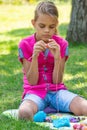 Girl knits on a knitting needles on a picnic in nature