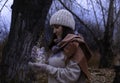 A girl in a knitted hat holds a jar with a garland in her hands, admires the flickering of lights. Royalty Free Stock Photo