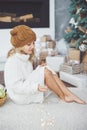 girl in knitted hat near christmas tree makes a wish for new year Royalty Free Stock Photo