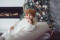 girl in knitted hat near christmas tree makes a wish for new year Royalty Free Stock Photo