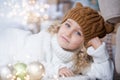 girl in knitted hat near christmas tree makes a wish for new year Royalty Free Stock Photo