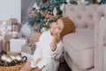 girl in knitted hat near christmas tree makes a wish for new year Royalty Free Stock Photo