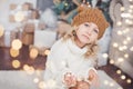 girl in knitted hat near christmas tree makes a wish for new year Royalty Free Stock Photo