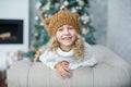 girl in knitted hat near christmas tree makes a wish for new year Royalty Free Stock Photo