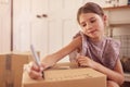 Girl Labelling Boxes Getting Ready For Moving Day Into New Home