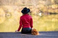 Girl lake autumn dog. A woman sits near a pond in autumn with a spitz dog. Royalty Free Stock Photo