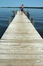 Girl on a lakeside dock Royalty Free Stock Photo