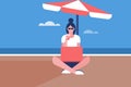 Girl sitting in a beach under umbrella and working on her laptop Royalty Free Stock Photo