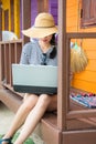 Girl on laptop in front of the beach house Royalty Free Stock Photo