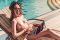 Girl with laptop near swimming pool Royalty Free Stock Photo