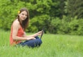 Girl with laptop relaxing on the grass Royalty Free Stock Photo