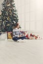 Young woman online on laptop at christmas interior Royalty Free Stock Photo