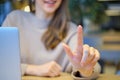 Girl with a laptop at the table abstractly presses a finger