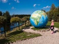 Girl with large globe at Dinosaurs Theme Park, Leba, Poland Royalty Free Stock Photo