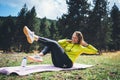 Girl laughing exercising outdoors in sun summer day, smile fitness woman stretching exercises training outside in green forest Royalty Free Stock Photo