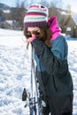 Girl laughing and holding a pair skis Royalty Free Stock Photo