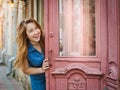 Girl laughs and opens the door to the old house on the street in the city. Free place Royalty Free Stock Photo