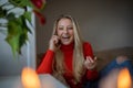 A girl laughs while talking on the phone at home sitting on her sofa, happiness concept Royalty Free Stock Photo