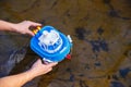 Girl launches a toy boat in the forest creek