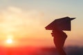 A girl is launching a paper airplane from a window at sunset. Royalty Free Stock Photo