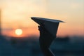 A girl is launching a paper airplane from a window at sunset. Support of the Telegram application and freedom internet. Royalty Free Stock Photo