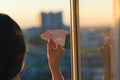 A girl is launching a paper airplane from a window at sunset. Support of the Telegram application and freedom internet. Royalty Free Stock Photo