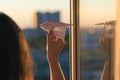 A girl is launching a paper airplane from a window at sunset. Support of the Telegram application and freedom internet. Royalty Free Stock Photo