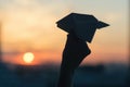 A girl is launching a paper airplane from a window at sunset. Support of the Telegram application and freedom internet. Royalty Free Stock Photo