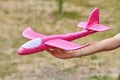 Girl launching a pink toy plane into the air