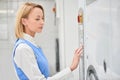 Girl Laundry worker chooses washing program Royalty Free Stock Photo