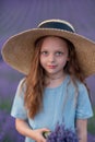 Girl lavender field in a blue dress with flowing hair in a hat stands in a lilac lavender field Royalty Free Stock Photo