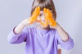 A girl in a lavender long sleeve stretches an orange slime with her hands