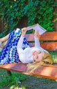 Girl lay bench park relaxing with book, green nature background. Woman spend leisure with book. Time for self Royalty Free Stock Photo