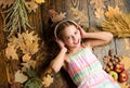 Girl lay fallen leaves wooden background. Music application for youth modern gadget. Child girl listen music headphones