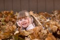 Girl laying in leaf pile play playing