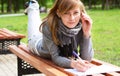 The girl lays on a bench, and writes Royalty Free Stock Photo
