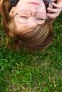 The girl lays on a grass with phone