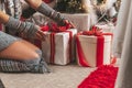 A girl lays out gifts under a christmas tree