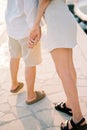 Girl leaned towards guy, holding his hand. Cropped. Faceless