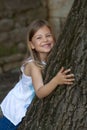 Girl leaning on oak tree Royalty Free Stock Photo