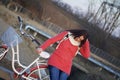 The girl leans on a parked bike and straightens her hair. Rest on the spring cycle Royalty Free Stock Photo