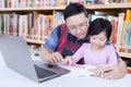 Girl learn to write in the library with a teacher Royalty Free Stock Photo