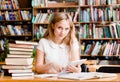 Girl learning in library and reading e-book on tablet computer Royalty Free Stock Photo