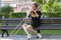 Girl learning to play trombone. Girl plays sitting on a park bench