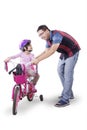 Girl learning to ride a bicycle with father Royalty Free Stock Photo