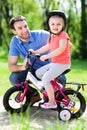 Girl learning to ride a bike with her father Royalty Free Stock Photo