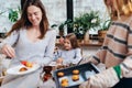 Girl learns her lessons in the kitchen while her mother and her friend make dinner Royalty Free Stock Photo